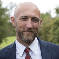 a bald man wearing a suit and tie